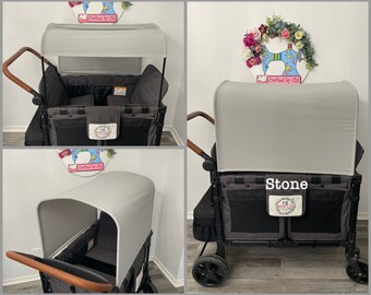May include: A gray and black wagon with a canopy. The wagon has a brown handle and black wheels. The canopy is labeled "Stone". The wagon has multiple storage pockets and a padded interior.