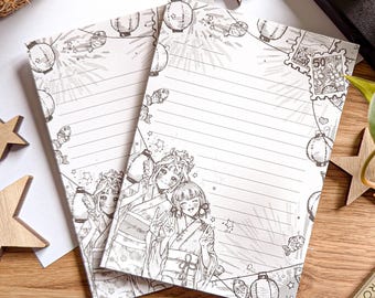 May include: Two lined notepads with a black and white illustration of anime-style characters in traditional Japanese clothing. The border features lanterns, fish, and stars. A postage stamp graphic is in the upper right corner.