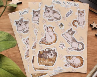 May include: A set of three vinyl sticker sheets featuring cute cats in various poses. The stickers are printed on a light beige background with paw prints. The text on the sticker sheet reads "Pulla & Mörkö Vinyl sticker sheet".
