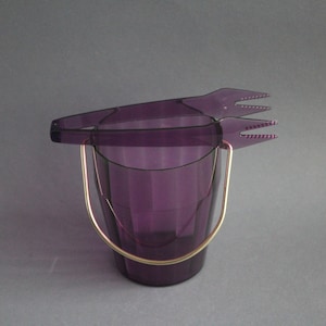 Vintage ice cube tray made of transparent purple plastic with ice cube tongs and gold metal handle
