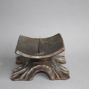 Antique bronze candle holder with a square candle holder on four feet, estimated to be from the early 19th century