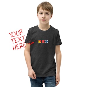 May include: A dark heather grey youth t-shirt with a small graphic of three nautical signal flags. The flags are yellow, red, and blue. The text "YOUR TEXT HERE" is written in red on the left side of the image.