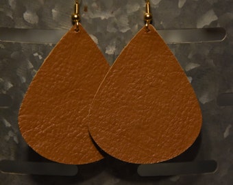 Peut inclure: Une paire de boucles d'oreilles en forme de goutte d'eau en cuir marron avec des crochets dorés.