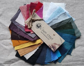May include: A fan-shaped color chart of fabric swatches in various colors, including red, blue, green, yellow, and brown. The swatches are arranged in a circle around a small card with the text "Linen roses" and the website address "www.linenroses.com".