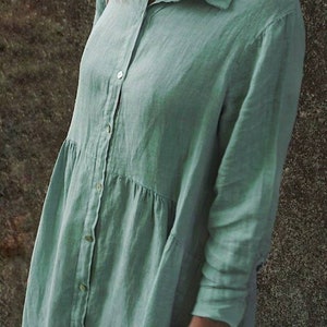 May include: A long-sleeved, light green linen shirt dress with a button-up front and a collared neckline.