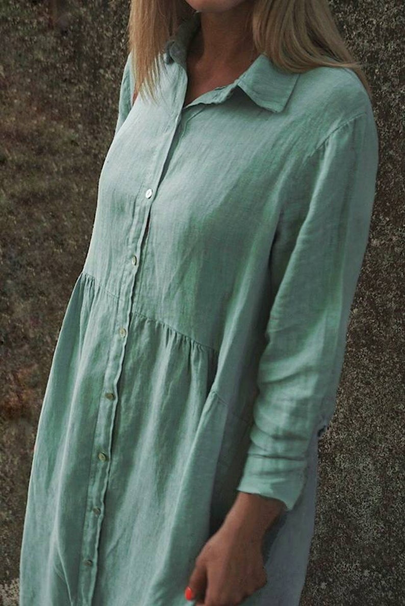 May include: A long-sleeved, light green linen shirt dress with a button-up front and a collared neckline.