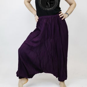 May include: Purple, loose-fitting pants with a wide, flowing leg. The pants have a drawstring waistband and are made of a soft, comfortable fabric.