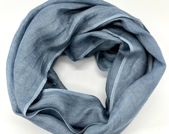 May include: A soft, blue scarf with a subtle sheen. The scarf is made of a lightweight fabric and has a simple, elegant design.