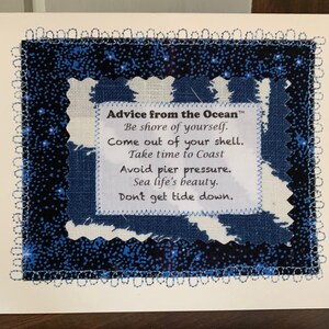 May include: A blue and white fabric with a white border and a white tag with the text "Advice from the Ocean™" and the following text: "Be shore of yourself. Come out of your shell. Take time to Coast Avoid pier pressure. Sea life's beauty. Don't get tide down."