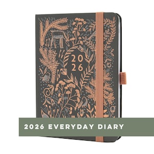 Peut inclure: Un agenda quotidien 2026 gris foncé avec un motif floral et de cerf en pêche et gris. Il possède une fermeture élastique et un dos assorti. Le texte "2026" est bien visible sur la couverture.