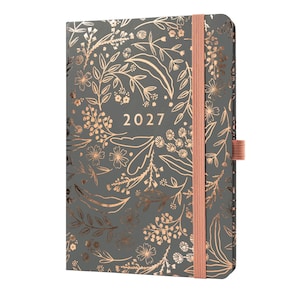 May include: A dark grey planner with a rose gold floral pattern and the year 2027 printed in the centre. The planner features a vertical rose gold elastic band closure and a matching elastic pen loop on the right side of the cover.