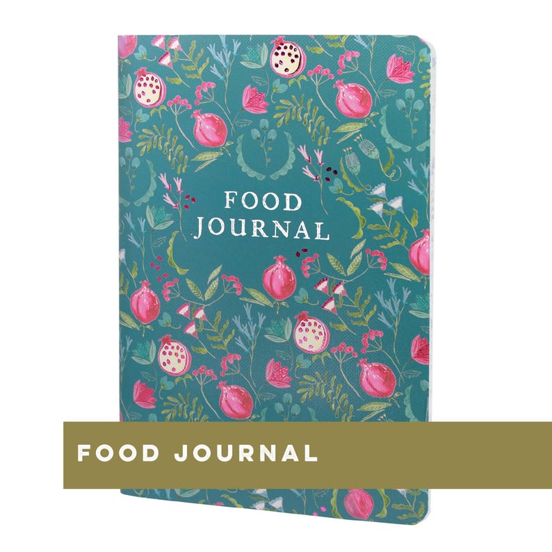 May include: A teal food journal with a floral pattern of pink pomegranates and white flowers. The words "FOOD JOURNAL" are printed in white on the cover. The journal is rectangular and has a gold-colored band at the bottom with the words "FOOD JOURNAL".