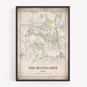 Może przedstawiać: Oprawiony wydruk mapy The Woodlands, Teksas, z szczegółowym układem ulic i zielonych terenów. Mapa ma estetykę vintage z beżowym tłem i czarną ramą. Tekst na dole brzmi "THE WOODLANDS Texas".