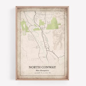 Könnte beinhalten: Ein gerahmter Kartendruck von North Conway, New Hampshire, mit Vintage-Ästhetik. Die Karte zeigt ein detailliertes Layout von Straßen, Wasserwegen und Grünflächen. Der Text "North Conway" und Koordinaten werden unten angezeigt.