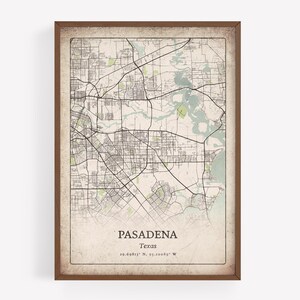 May include: A framed map print of Pasadena, Texas, featuring a detailed street layout in black lines against a beige background. The map includes green and blue areas representing parks and water bodies. The city name and coordinates are printed at the bottom.