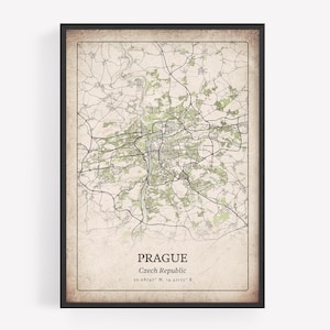 May include: Framed map print of Prague, Czech Republic, with a vintage aesthetic. The map features a detailed depiction of the city's streets and green spaces, with the city name and coordinates at the bottom. The frame is black.