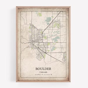 Può includere: Una stampa incorniciata della mappa di Boulder, Colorado, con una planimetria dettagliata delle strade e delle aree circostanti. La mappa ha un'estetica vintage con uno sfondo beige e accenti verdi e blu. Il nome della città e le coordinate sono stampati in basso.