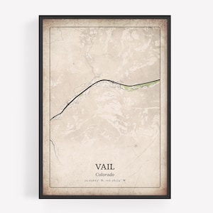 May include: Framed map print of Vail, Colorado, in a vintage style. The map features a detailed outline of the area with a black border and text that reads "VAIL Colorado" along with the coordinates. The print has a neutral color palette.