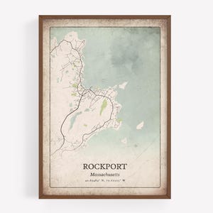 May include: Framed vintage-style map print of Rockport, Massachusetts, with a brown wooden frame. The map features roads, water, and land in muted green and beige tones. The town's name and coordinates are printed at the bottom.