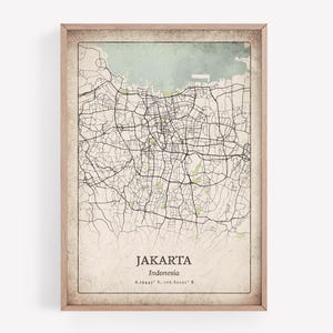 Puede incluir: Una impresión enmarcada de un mapa de Yakarta, Indonesia, con una estética vintage. El mapa presenta una red detallada de carreteras y calles en negro sobre un fondo beige, con un área verde claro que representa el mar. El nombre de la ciudad y las coordenadas están impresos en la parte inferior.