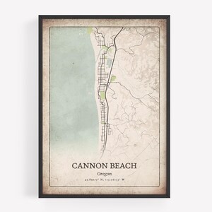 Może przedstawiać: Oprawiony wydruk mapy Cannon Beach, Oregon, z szczegółową mapą ulic i zarysem wybrzeża. Mapa ma wygląd vintage z jasnym zielonym i beżowym schematem kolorów. Widoczny jest tekst "Cannon Beach" i współrzędne.