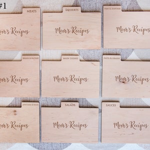 May include: Nine wooden recipe card dividers with the text "Mom's Recipes" on each. The dividers are labeled with different recipe categories, including meats, desserts, fish & seafood, breads & pastries, main dishes, pasta & grains, appetizers & soups, salads, and sauces.
