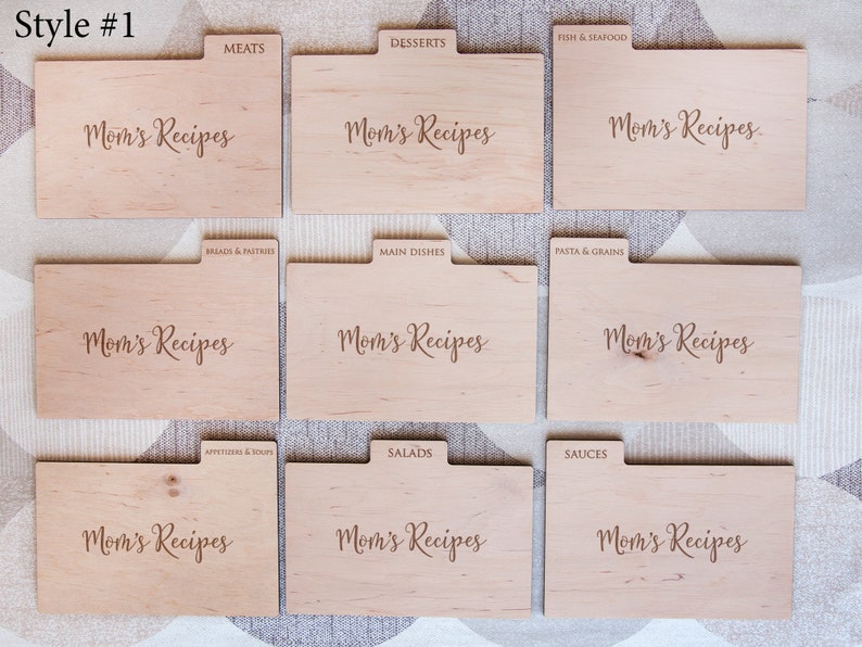 May include: Nine wooden recipe card dividers with the text "Mom's Recipes" on each. The dividers are labeled with different recipe categories, including meats, desserts, fish & seafood, breads & pastries, main dishes, pasta & grains, appetizers & soups, salads, and sauces.
