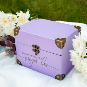 May include: A lavender wooden box with brass accents and the inscription "The Smith's Family Prayer Box".