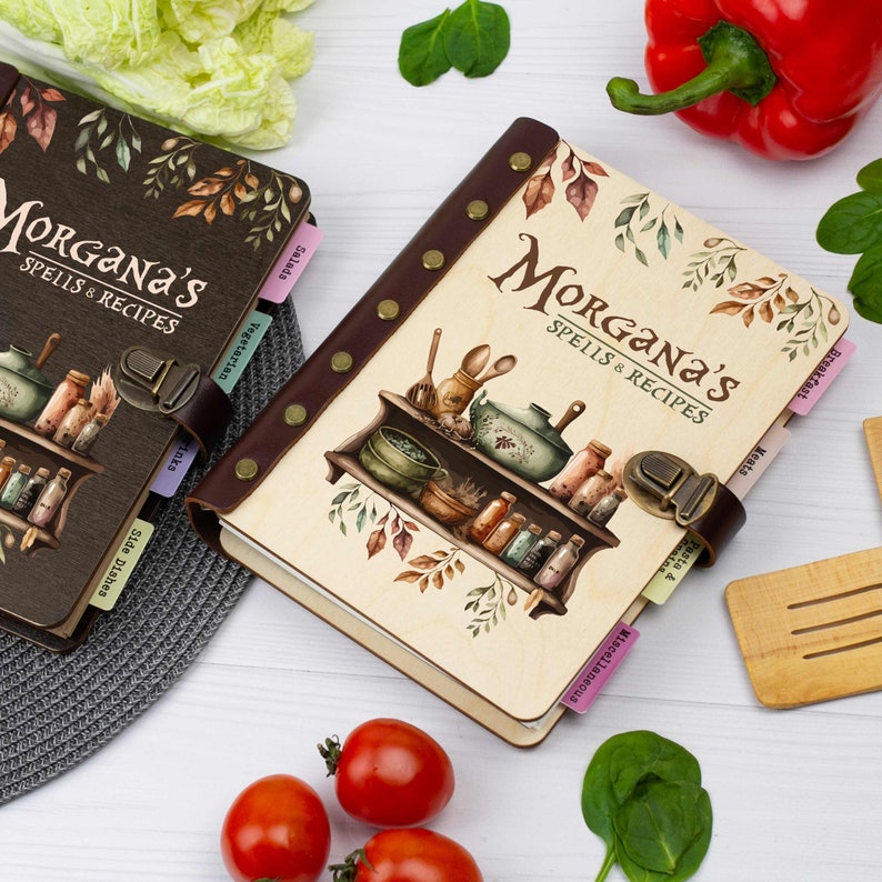 Pu&ograve; includere: Due diari rilegati in pelle marrone con il titolo "Morgana's Spells & Recipes" sulla copertina. I diari hanno schede per diverse categorie, come "Colazione", "Carne", "Pasta e piatti principali", "Insalate", "Vegetariano", "Contorni" e "Varie". I diari sono decorati con un'illustrazione ad acquerello di uno scaffale con diverse bottiglie e barattoli.