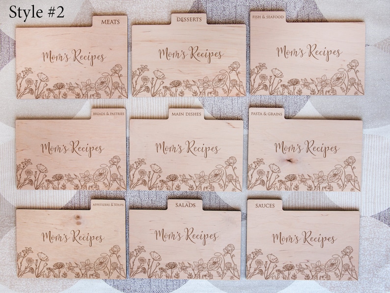 May include: Nine wooden recipe card dividers with a floral design and the text "Mom's Recipes". Each divider has a different category label, such as "Meats", "Desserts", "Breads & Pastries", "Main Dishes", "Pasta & Grains", "Appetizers & Soups", "Salads", and "Sauces".