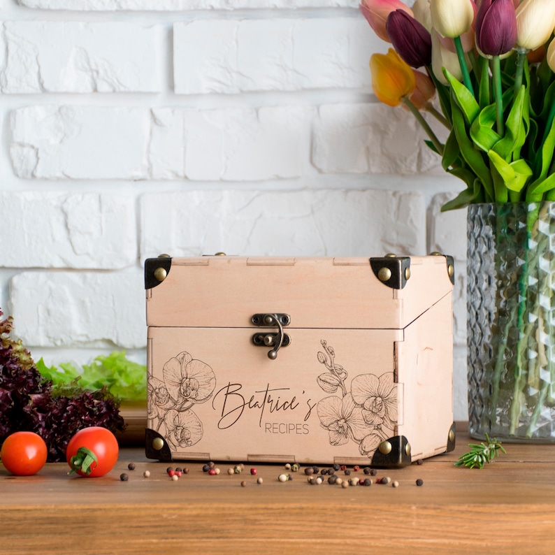 May include: A handmade wooden sign displaying the word "Welcome" in a whimsical font. It has a distressed white background and a dark brown frame, suitable for a front door or hallway.