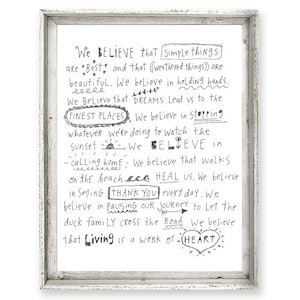 May include: Black and white typography print with the text "We believe that simple things are best..." and other inspirational quotes about life, dreams, and nature. The print is framed in a white frame.