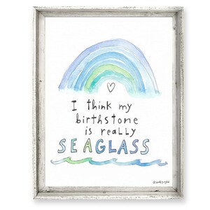 May include: A watercolor painting of a rainbow with a heart at the top. The text below reads "I think my birthstone is really SEAGLASS".