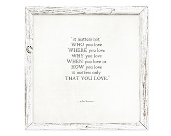 May include: A framed print with a white background and a black quote by John Lennon that reads "it matters not WHO you love WHERE you love WHY you love WHEN you love or HOW you love it matters only THAT YOU LOVE."
