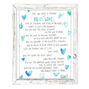 May include: A watercolor print with a blue and green color scheme featuring a poem about beach love. The poem reads "May you have a lifetime of beach love... days of sunshine and kisses in the dunes, nights filled with moondance, may you ride the waves of happy all the way to shore. May you look to horizons together, and may your individual dreams set sail. May you breathe in the beautiful moments. May you hold to each other in bad weather, ride the bumper cars of life and laugh. May you bend like dune grass when the winds change. May you stop whatever you're doing and take time to watch the sunset. And may you always remember that the journey itself is home..."