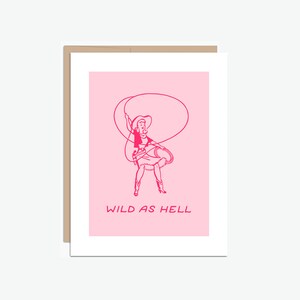 May include: Pink greeting card with a line drawing of a woman in a cowboy hat and skirt, holding a lasso. The text "WILD AS HELL" is printed below the image.
