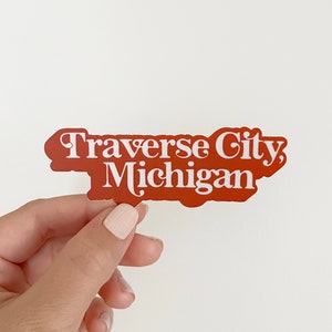 May include: A red sticker with white text that reads "Traverse City, Michigan".