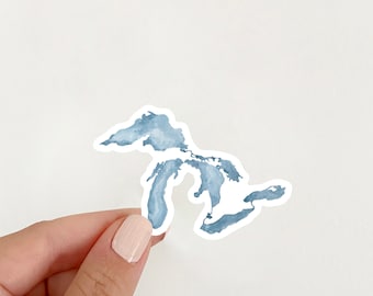 May include: A blue watercolour sticker of the Great Lakes. The sticker is shaped like the Great Lakes and has a white outline.