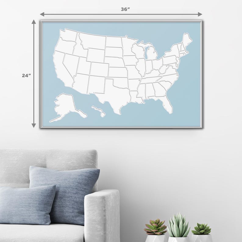 May include: A white outline map of the United States with state borders, on a light blue background. The map is framed in a silver frame and measures 24 inches by 36 inches.