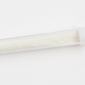 May include: A clear plastic tube filled with white glitter.