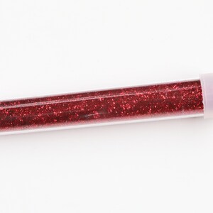 May include: A clear plastic tube filled with red glitter.