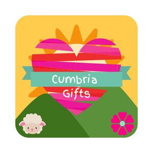 May include: A yellow, green, and pink illustration of a heart with a sun behind it. The heart has red and pink stripes. The text "Cumbria Gifts" is on a blue ribbon in front of the heart.