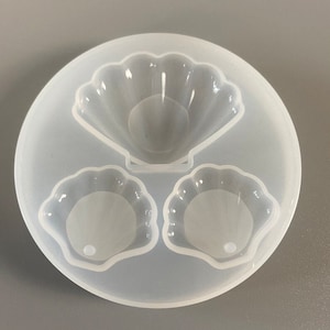 May include: A clear silicone mould with three shell shapes. The mould is designed to create resin crafts.
