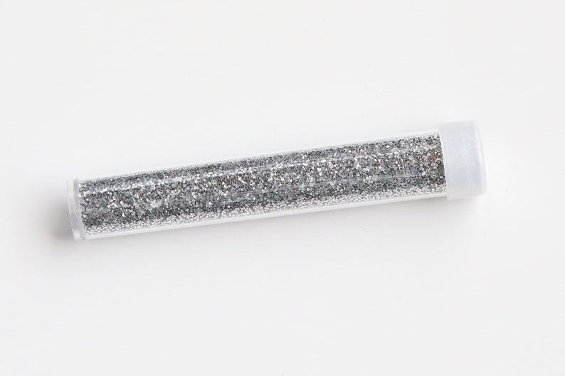 May include: A clear plastic tube filled with silver glitter.