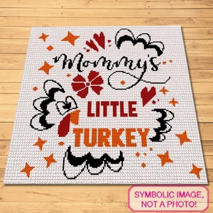 Puede incluir: Una manta de crochet blanca con el texto "Mommy's Little Turkey" en letras naranja, rojo y negro. El diseño incluye corazones, estrellas y una ilustración de pavo.