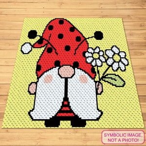 May include: A crochet gnome with a red and black ladybug hat holding a white flower with green leaves. The gnome is standing on a yellow background.