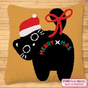May include: A crocheted pillow with a black cat design wearing a Santa hat and a red bow. The words "MERRY XMAS" are written on the cat's back in red and green. The pillow is yellow.