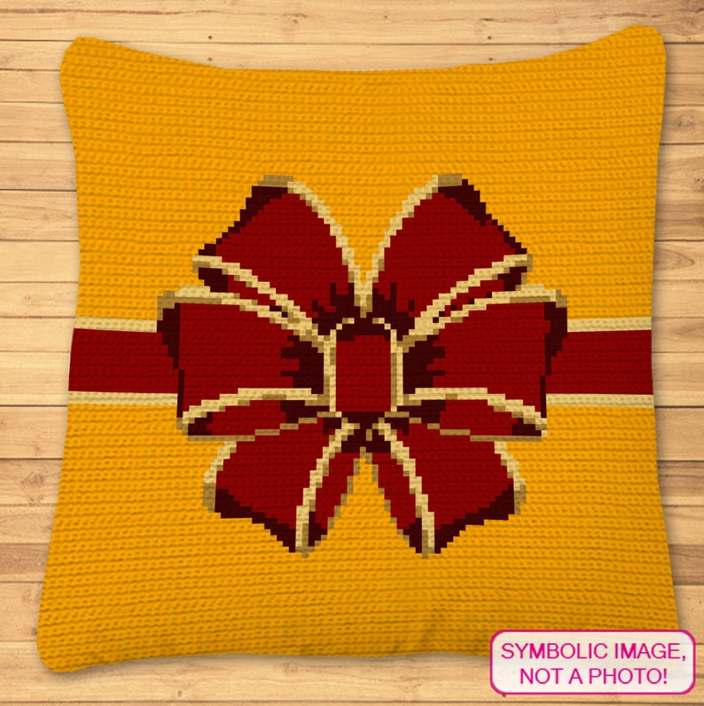 May include: A yellow crocheted pillow with a red bow and a gold ribbon. The pillow has a textured surface and the text "SYMBOLIC IMAGE, NOT A PHOTO!" is printed on the bottom right corner.