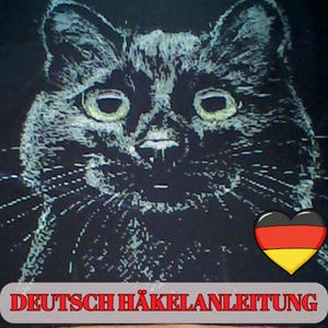 May include: A black cat illustration with white highlights and green eyes. The image includes the text "DEUTSCH HÄKELANLEITUNG" in a red banner, and a heart with the German flag colors.