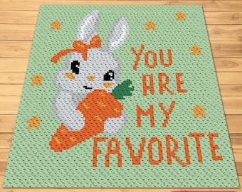 Pode incluir: Uma manta de crochê verde com um coelho branco segurando uma cenoura. O texto "You are my favorite" está escrito em laranja na manta.
